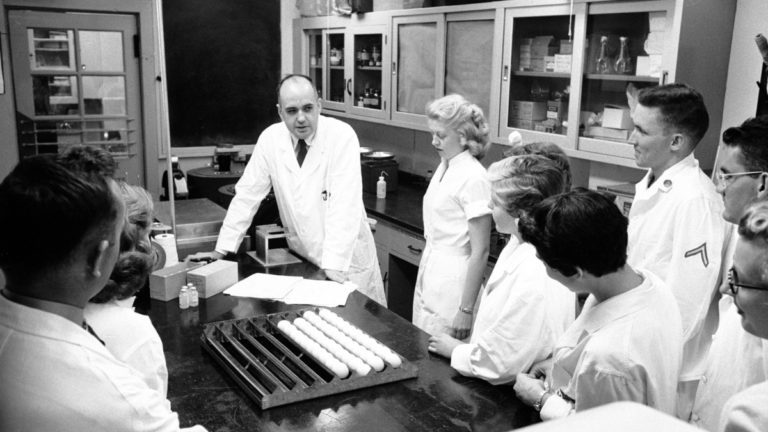 موريس هيلمان متوسطًا فريقه البحثي الذي كان يعمل على علاج للأنفلونزا الآسيوية